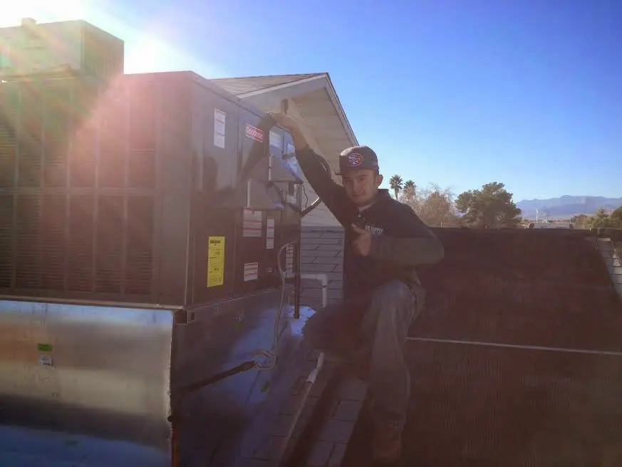 HVAC technician performing HVAC Inspection on a rooftop unit in Munster